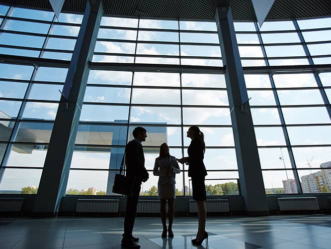 three business people meeting in a large lobby